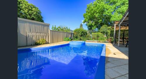 a large blue swimming pool in a yard at Ambrosia Holiday Home in Tanunda