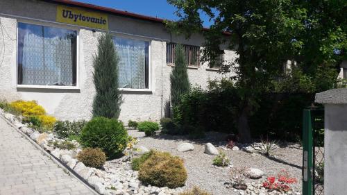 a garden in front of a building with plants at Apartman YVET in Sučany
