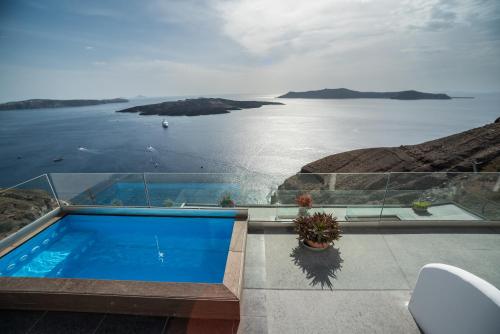a house with a swimming pool and a view of the ocean at Kratiras View Luxury Suites in Fira