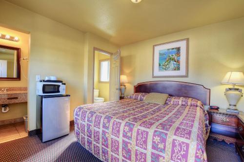 a hotel room with a bed and a microwave at Bayside Inn in Monterey