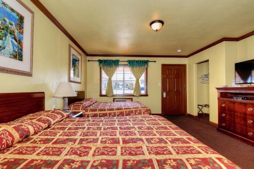 a hotel room with two beds and a television at Bayside Inn in Monterey