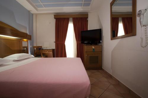 a bedroom with a bed and a flat screen tv at Hotel Katerina in Athens