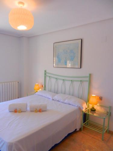 a bedroom with a large white bed with two lamps at Oceanográfico Apartments in Valencia