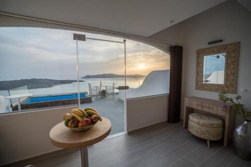 a room with a bowl of fruit on a table at Kratiras View Luxury Suites in Fira