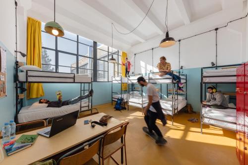 a room filled with bunk beds and desks at Fabrika Hostel & Suites in Tbilisi City