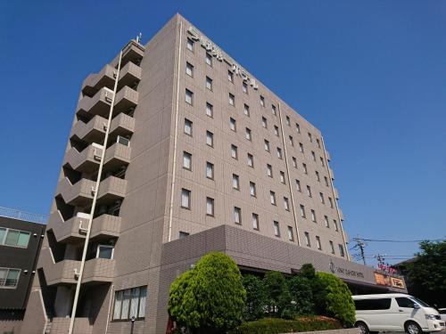 a tall building with a van parked in front of it at Yono Daiichi Hotel in Saitama