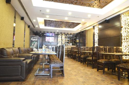 a restaurant with leather chairs and tables and a bar at Hotel Metro View in New Delhi