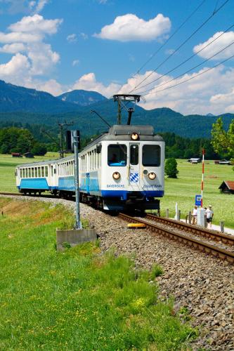 a white and blue train on the tracks at Berghotel Hammersbach in Grainau