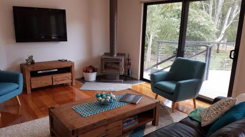 a living room with a couch and a table and a fireplace at Golton in the Gap in Halls Gap