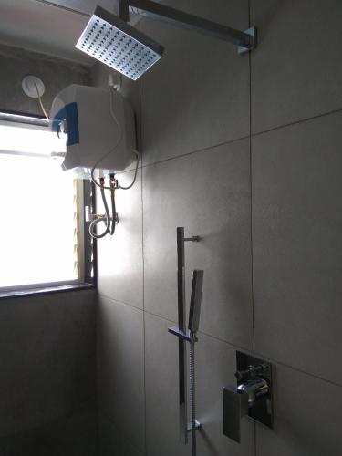 a bathroom with a shower and a light on the wall at Manasi Pride in Satara