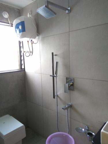 a bathroom with a shower with a toilet and a sink at Manasi Pride in Satara