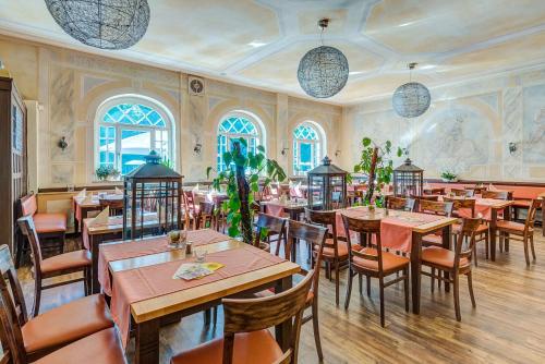 a restaurant with tables and chairs in a room at Hotel zur Kanone in Tautenhain