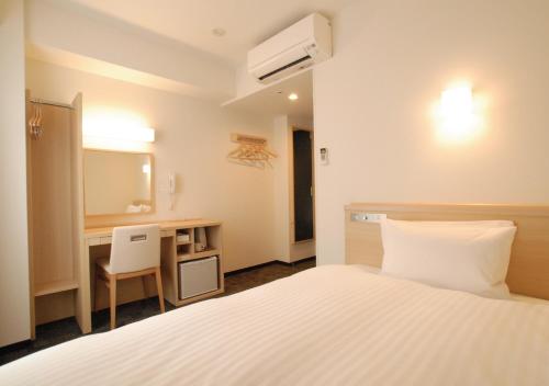a hotel room with a bed and a desk and a mirror at AB Hotel Kyoto Shijo Horikawa in Kyoto
