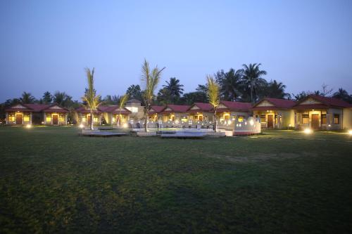 a resort with lights in a field at night at Breathing Earth - Rooms and Pool in Kolkata