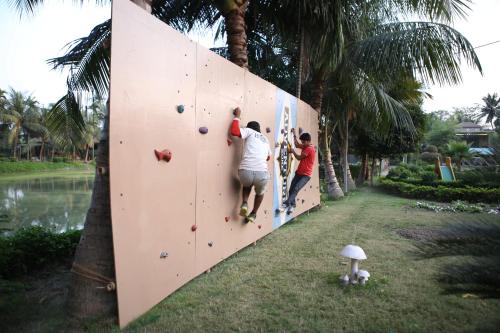 a group of people climbing on a climbing wall at Breathing Earth - Rooms and Pool in Kolkata