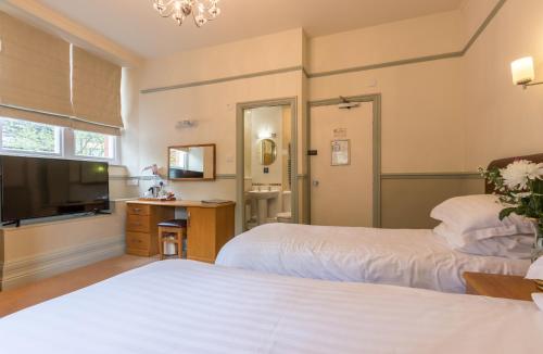a hotel room with two beds and a television at Windermere Park B&B inc Free off-site Health Club in Windermere