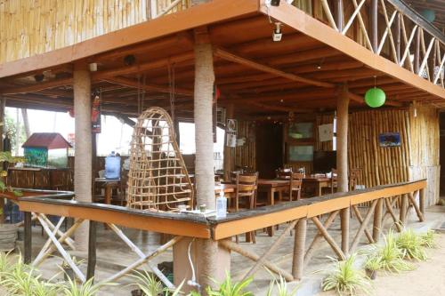 a large wooden building with a table and chairs at Scoop Cabana Kitesurfing in Kalpitiya