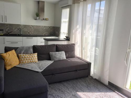 - un canapé gris dans le salon doté d'une fenêtre dans l'établissement Julie's Homes Disneyland, à Serris