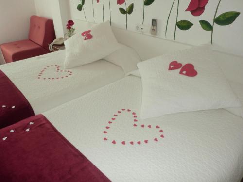 two beds with valentines pillows with hearts on them at Varandas de Alter Hotel & SPA in Alter do Chão