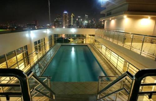 una piscina in cima a un edificio di notte di Herald Suites Solana a Manila