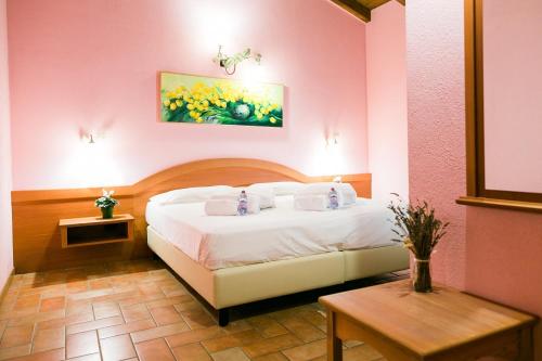 um quarto com uma cama branca num quarto cor-de-rosa em Fondo Brugarolo em Busnago