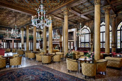 a hotel lobby with tables and chairs and a chandelier at Hotel Danieli, Venice in Venice
