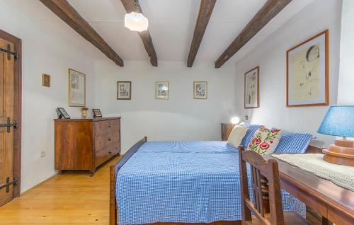 a bedroom with a blue bed and a wooden dresser at Apartment Kuharić in Grožnjan