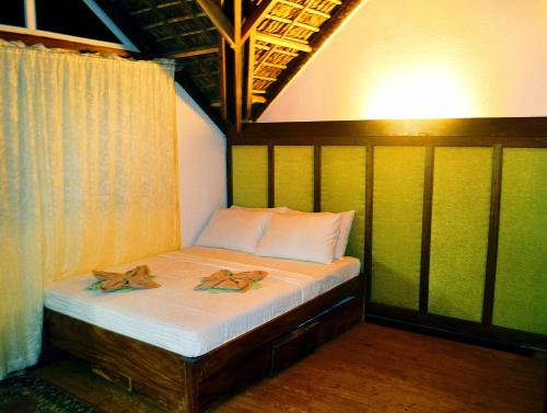a small bed in a room with two slippers on it at Alta Vista Ilocandia Inc. in Pagudpud