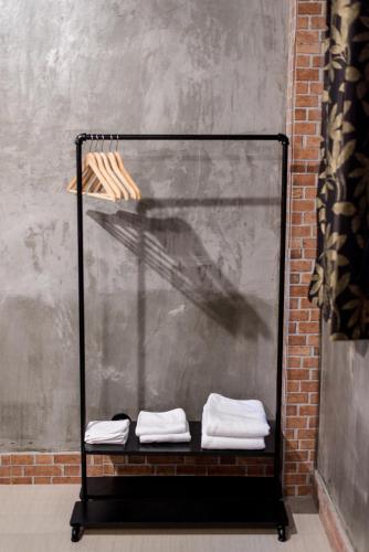 a shelf with two folded towels on it next to a wall at Sawatdee Guesthouse the Original in Bangkok