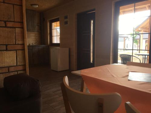 a kitchen and dining room with a table and chairs at Ptasie Siedlisko in Mikołajki