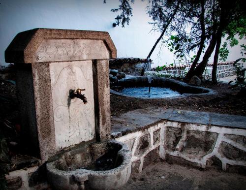 a stone box with a fountain in a park at Guest House Old Plovdiv in Plovdiv