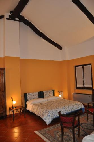 a bedroom with a bed and two chairs in it at Residenza Del Lago in Candia Canavese