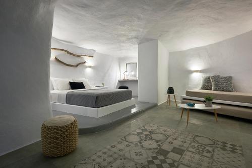 a white bedroom with a bed and a table at Terra Mare Suites in Agia Irini Milos