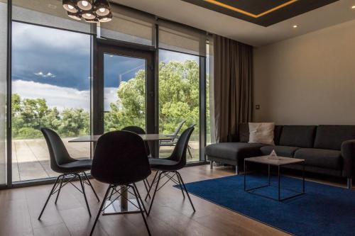 a living room with a couch and a table and chairs at Zala Springs Golf Resort in Zalacsány