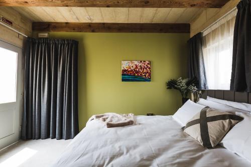 a bedroom with a white bed with a green wall at Talbot & Bons Bed & Breakfast in Gudja