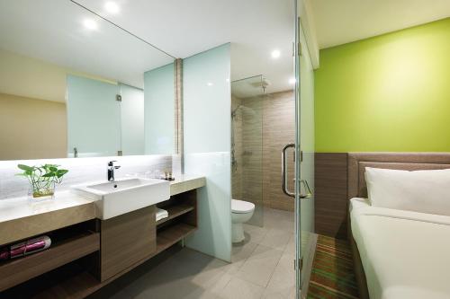 a bathroom with a sink and a toilet and a shower at Cosmo Hotel Kuala Lumpur in Kuala Lumpur