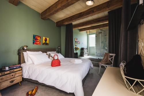 a bedroom with a large bed with a red bag on it at Talbot & Bons Bed & Breakfast in Gudja
