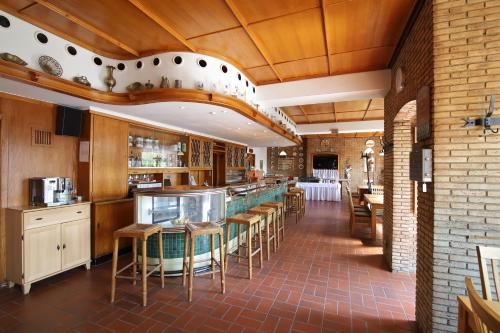 ein Restaurant mit einer Bar mit Tischen und Stühlen in der Unterkunft Hotel 12 Bäume in Werne an der Lippe