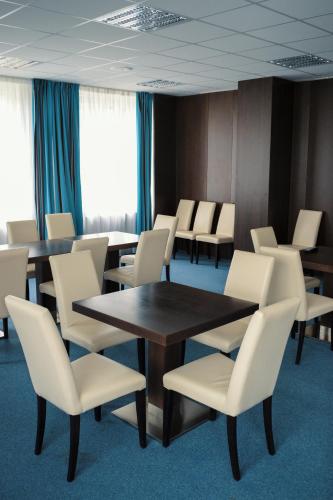 a conference room with tables and white chairs at Sport-Relax Centrum Bors Club in Břeclav