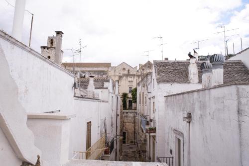 an alley between two white buildings with stairs at Dimora Maestà in Putignano