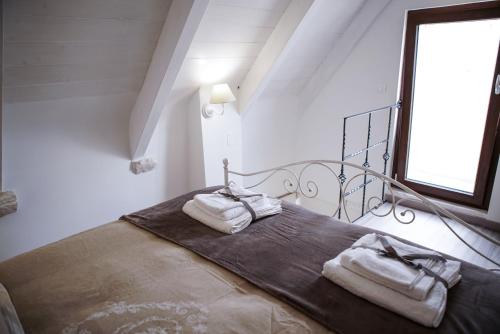 a bedroom with a bed with two towels on it at Dimora Maestà in Putignano