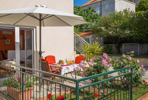 a patio with a table and an umbrella at Apartments Casa Toni Dubrovnik in Dubrovnik