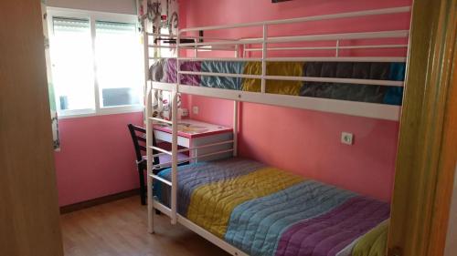 トレモリノスにあるPiso 3 dormitorios centro de Torremolinos 11349のピンクの壁のベッドルーム1室(二段ベッド1組付)