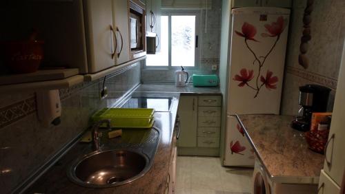 a small kitchen with a sink and a refrigerator at Piso 3 dormitorios centro de Torremolinos 11349 in Torremolinos