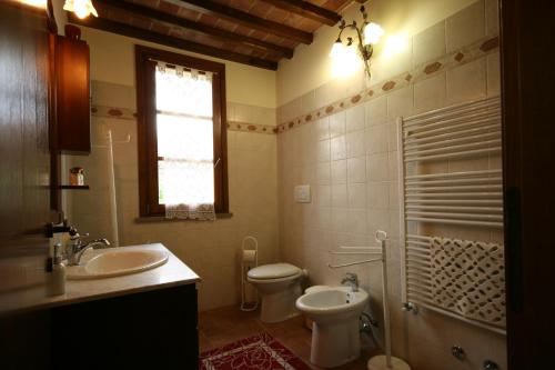 a bathroom with a sink and a toilet and a window at Casetta Singola vicino al Mare in Castagneto Carducci