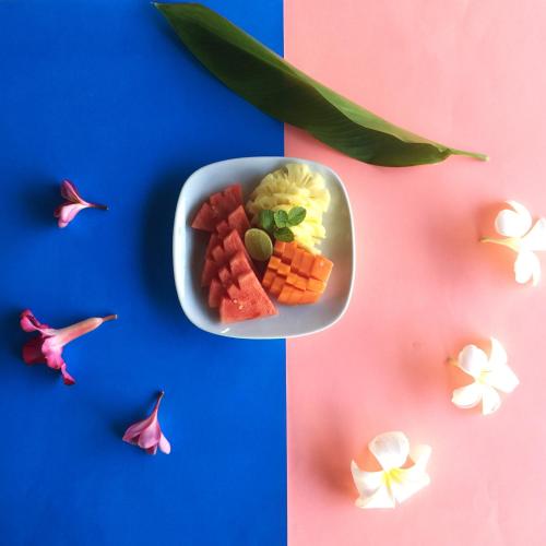 a bowl of food with vegetables and flowers on a table at Villa L'Orange Bali in Keramas