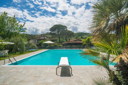 a swimming pool with a chair next to a house at Agriturismo Tontenano in Bucine