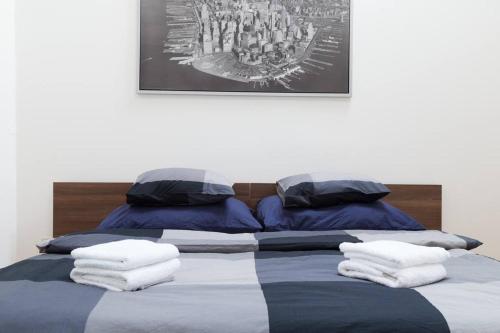 a bed with blue and white sheets and pillows at CityLife Residence in Bratislava