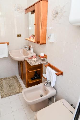 a white bathroom with a sink and a toilet at Casa Noto in Marettimo