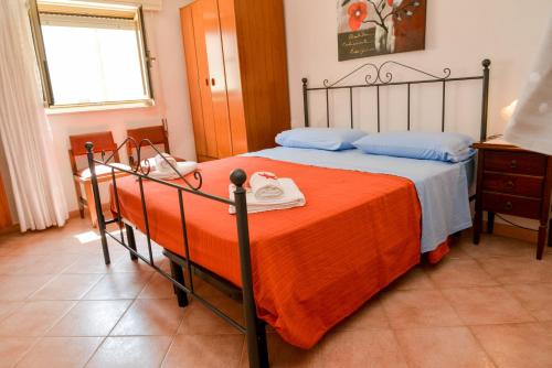 a bedroom with a bed with an orange blanket at Casa Noto in Marettimo